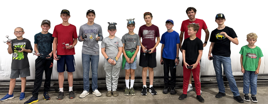 A group of boys standing in a line, wearing casual clothes and VR headsets.