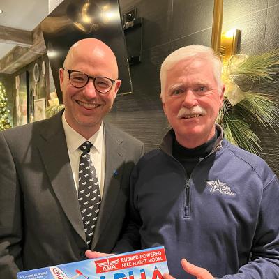 Two men holding model aircraft.