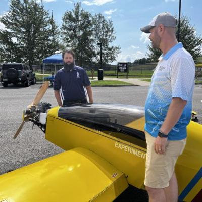 two men standing around a plane