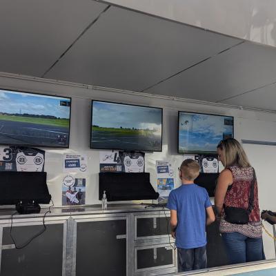 three people practicing their flying skills in the AMA Simulation Trailer