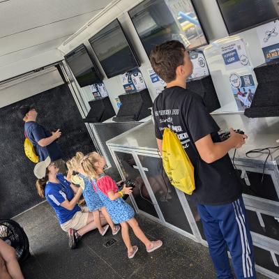 Young aviation enthusiasts practice flying in the AMA SIM Trailer 