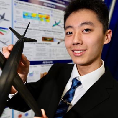 a young man holding a model plane