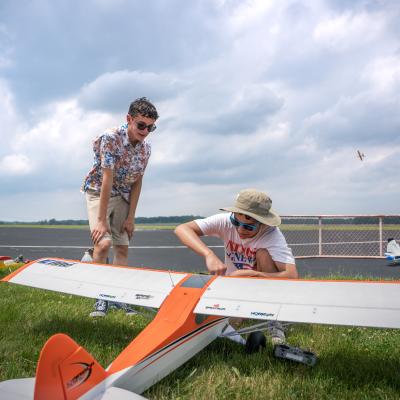 Two young model pilots looking at a model plane.