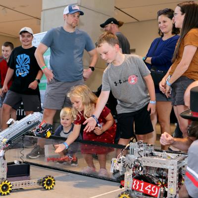 Child interacting with robots at Tinkerfest
