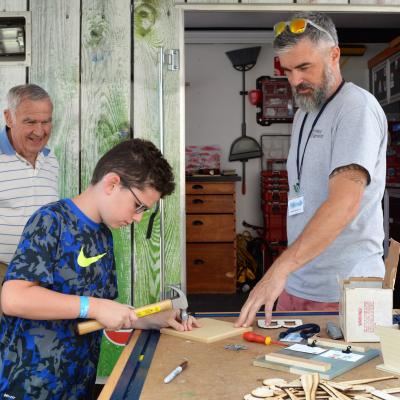 child doing woodworking at Tinkerfest event