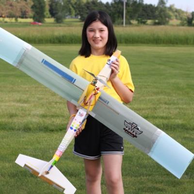 a woman holding a plane on a field