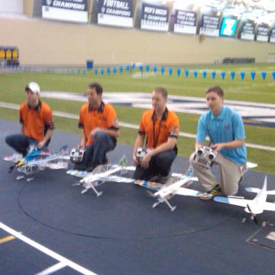 The 2015 United States Indoor Aerobatics Team with their aircraft (left to right) Ryan Clark, RJ Gritter, Devon McGrath, and Joseph Szczur
