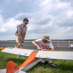 Two young model pilots looking at a model plane.