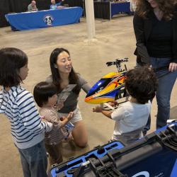 Gwen shows off model helicopter to event attendees. 
