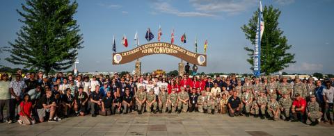 a group of people standing in front of a crowd posing for the camera