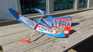 AMA Alpha rubber powered balsa wood model aircraft shown fully assembled with box, winder, and extra rubber
