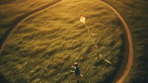 a kid flying a kite in a grassy field