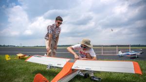 Two young model pilots looking at a model plane.