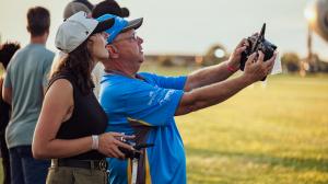 A young woman learns how to fly a model airplane from a mentor.