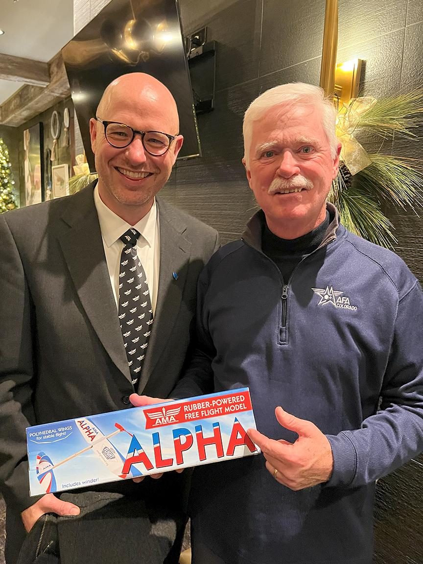 Two men holding model aircraft.