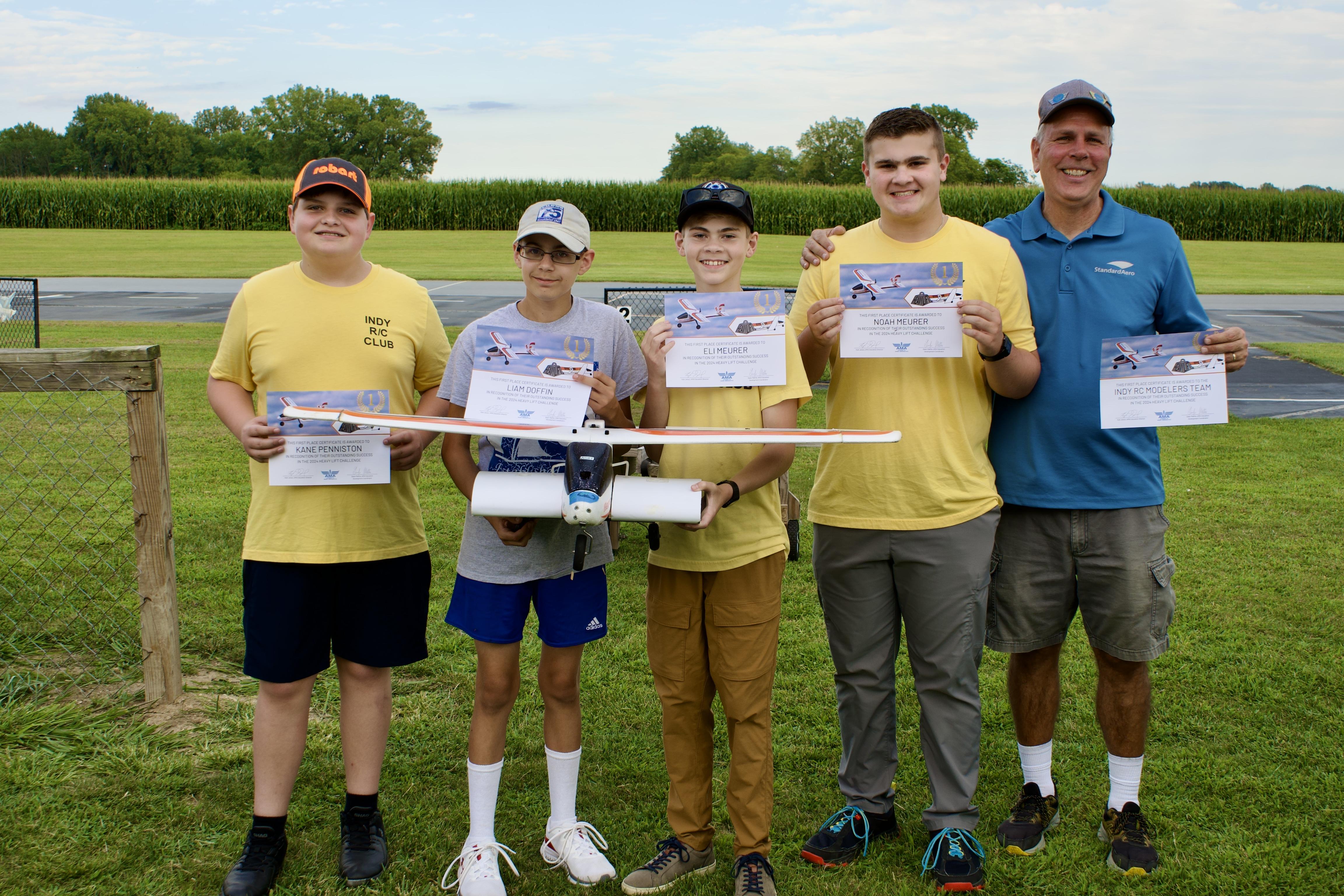 a group of youth standing in a grass field posing for the camera