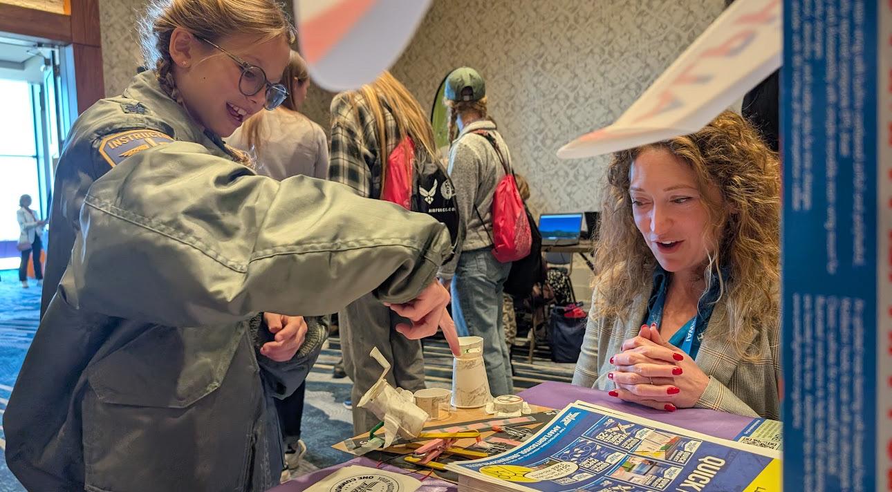 A woman and a child looking at the child's aviation project.