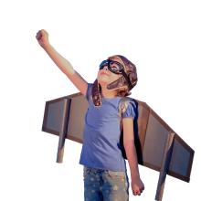 A child wearing cardboard wings and posing. 