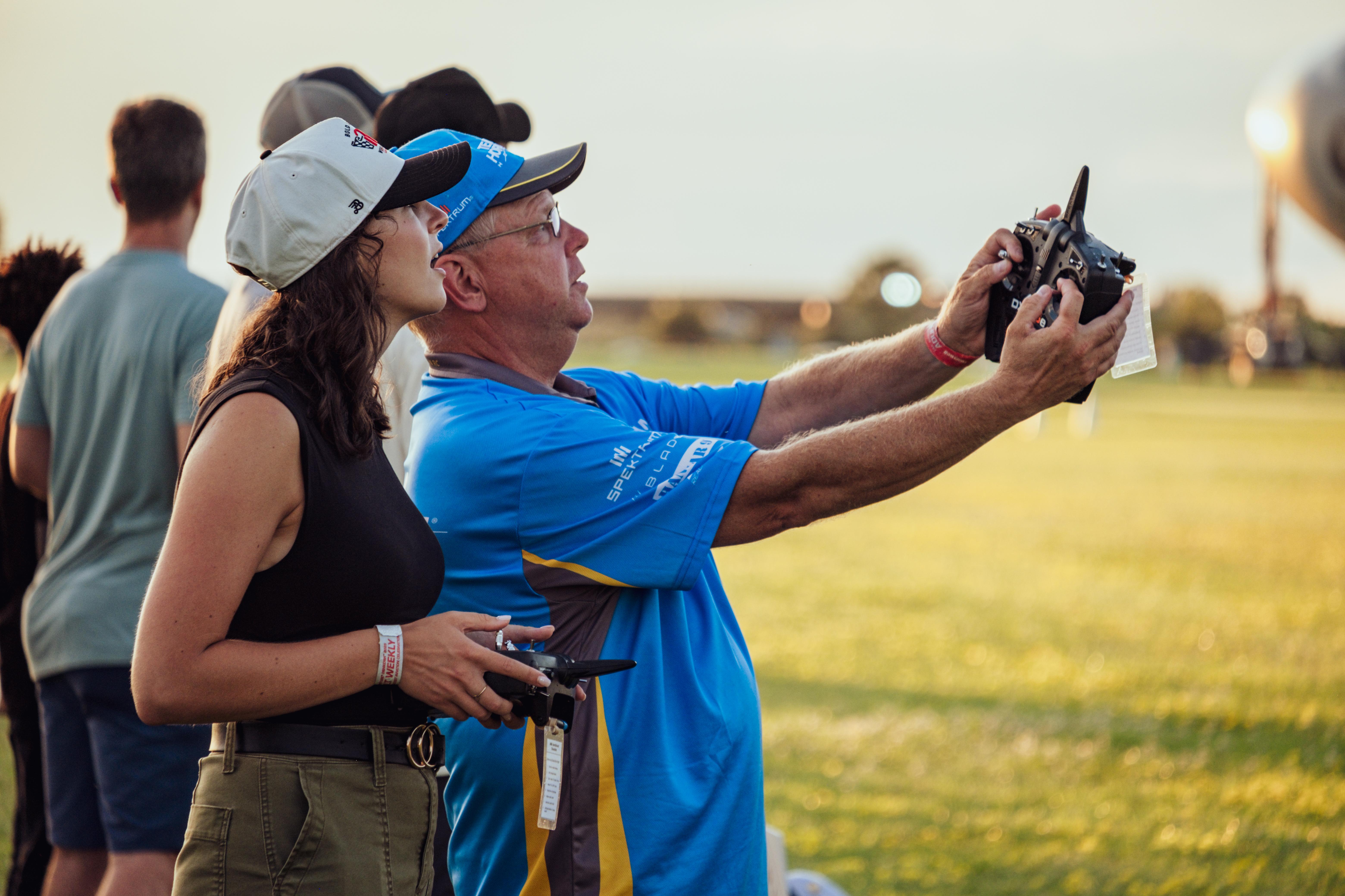 A young woman learns how to fly a model airplane from a mentor.